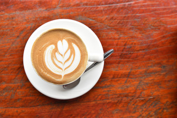 Coffee cup with latte art foam on wood table in coffee shop with copy space.Coffee is one of the most popular beverages.Improve Energy Levels and Burn Fat