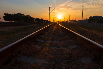 Fototapeta na wymiar Reflection of the sun on the rails at sunset