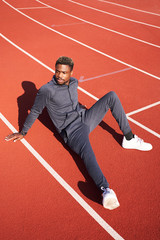 Dark-skinned guy in sportswear posing on the street. Exercise in the fresh air, lifestyle, sports field, rest in time sports.