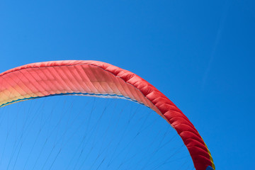 Obraz premium Detail of parachute (Fabric wing. Wing shape is maintained by the suspension lines) designed for paragliding with blue sky background