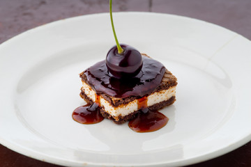 waffle cake with cherry and syrup on white plate