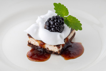 waffle cake with blackberry and whipped cream with mint leaf on white plate
