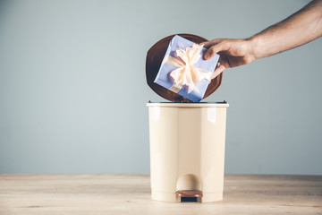 .man hand gift box on trash