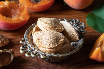 Apricot kernels and fresh apricots, dark photography