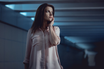 scared beautiful woman talking on smartphone in underpass