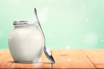 Healthy fresh  yogurt with spoon on background