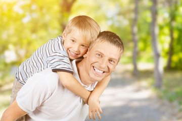 Happy father and son hugging on background