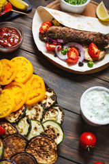 Assorted delicious grilled vegetables and doner kebab on a wooden background. Summer food.