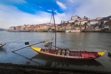 Traditional boats with barrels on the Douro river, Ribeira and Dom Luis bridge, Porto, Portugal.