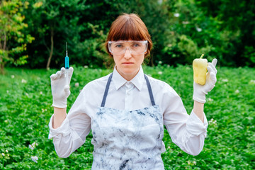 Scientist biologist in a lab coat and protective gloves introduces a blue liquid into the...