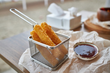 Fried cheese with sweet sauce served in a metal form at a restaurant