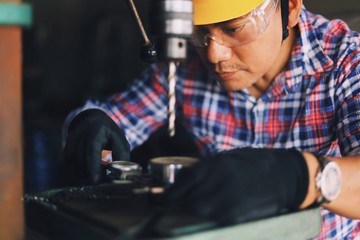 Smart Senior Asian man Engineering fixing machine in factory. 