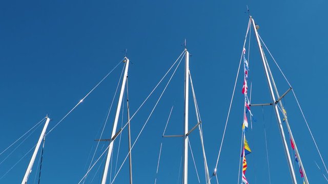 Nautical flags on the yachts masts against blue sky, Colorful signal flags on a sailing boat in sunshine