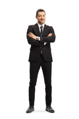 Busniessman wearing a black suit and posing with arms crossed
