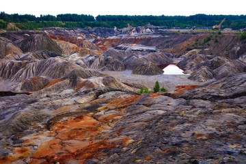 industrial clay hills and water in sunny day in Ural