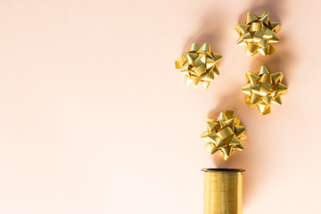 Gold ribbon with bow on pastel background.Gift box wrapping, wrapping materials. Christmas presents preparation.Copy space