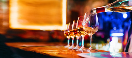 Wine serving in glasses in night club bar restaurant | Blurred background - obrazy, fototapety, plakaty