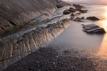 Sunset with its impacted rock formations on Itzurun beach (Zumaia, Basque country, Spain)