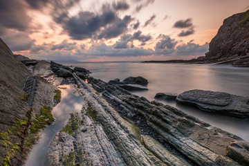 Sunset with its impacted rock formations on Itzurun beach (Zumaia, Basque country, Spain)