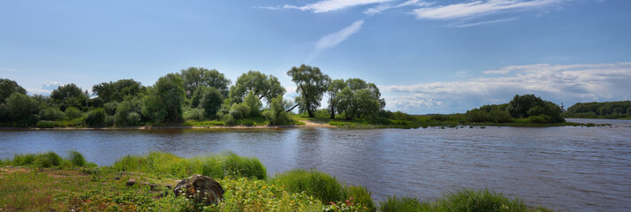 Large-format summer panorama with a river and a picturesque shore