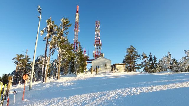 Zlatibor Tornik ski resort chalet antennas snowy ground over shadows across white powder from sunlight.