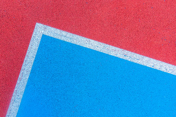Colorful sports court background. Top view to red and blue field rubber ground with white lines outdoors