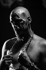 Fototapeta na wymiar black and white portrait of a brutal man tearing the chain