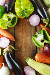 Fresh vegetables and ingredients for cooking around vintage cutting board on rustic background, top view, place for text. Vegan food, vegetarian and healthily cooking concept. Flat lay composition