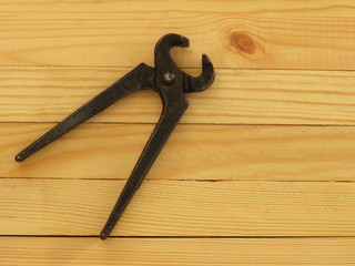 Old rusty pincers on a wooden background. A tool for gripping and pulling things.