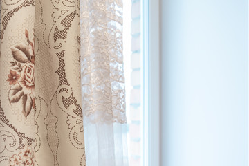 Curtains and tulle on the window and light from the window as a background for the design.