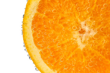 Ripe orange slice in water against white background, closeup