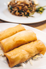 Fried spring rolls on black slate plate on grey stone slate background. Top view
