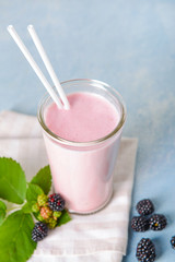 Glass of tasty blackberry smoothie on table