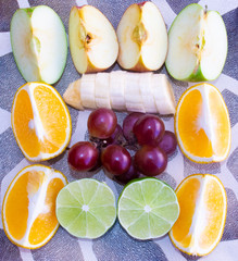 Orange, banana, lemon, apple and grapes, sliced ​​in half. Top view