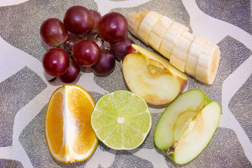 Sliced ​​fruits on a plate on the table. top view.
