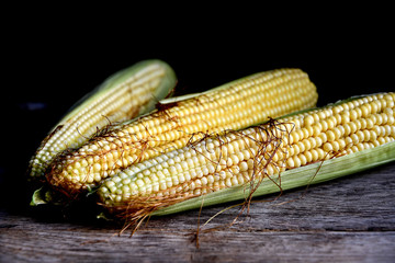 Young fruits of corn on an old rustic table.