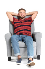 Obraz premium Handsome young man relaxing in armchair against white background