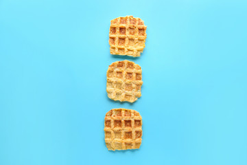 Tasty waffles on color background