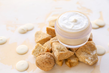 Jar of natural cream and lump brown sugar on table