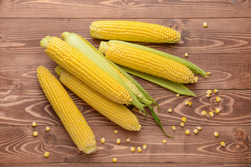 Fresh corn cobs on wooden background