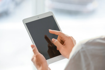Woman using tablet computer near window