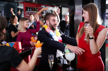 Guy flirting with girl on Hawaiian party at nightclub