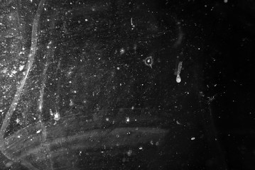 white dust and scratches on a black background. The texture of dirt on the glass.