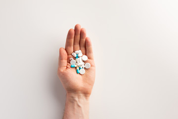Pills in hand, on white background. Flat lay.
