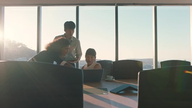 business people working late team leader woman meeting with colleagues discussing project manager sharing ideas on computer group of executives brainstorming in office at sunset