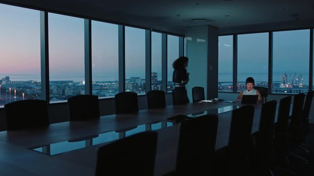business people working late using laptop computer in office boardroom colleagues work on project with deadline discussing ideas focused on success