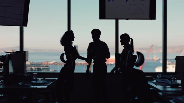 silhouette business people shaking hands consultant greeting international clients with handshake planning partnership deal female executive meeting shareholders in corporate office at sunset
