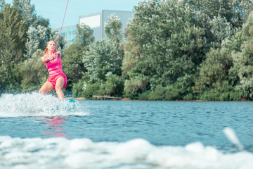 Beautiful young Caucasian girl wakeboarding on the river