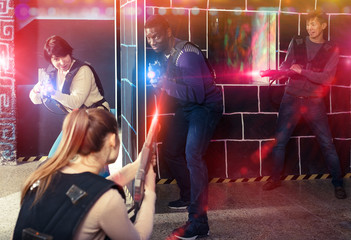 Fototapeta na wymiar group of adult people with laser guns having fun