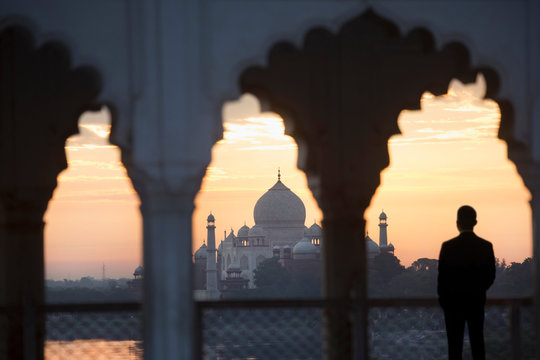 Rear view of man looking at Taj Mahal palace during sunset
